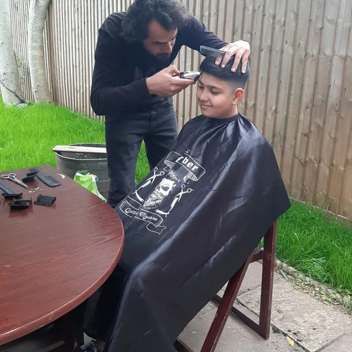 Client during haircut, striped cape